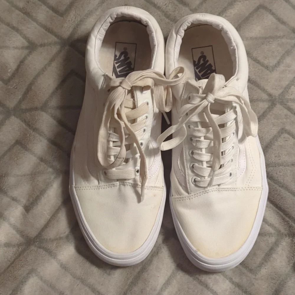 Vans Old Skool shoes in the True White or Monochrome‎ White colorway.